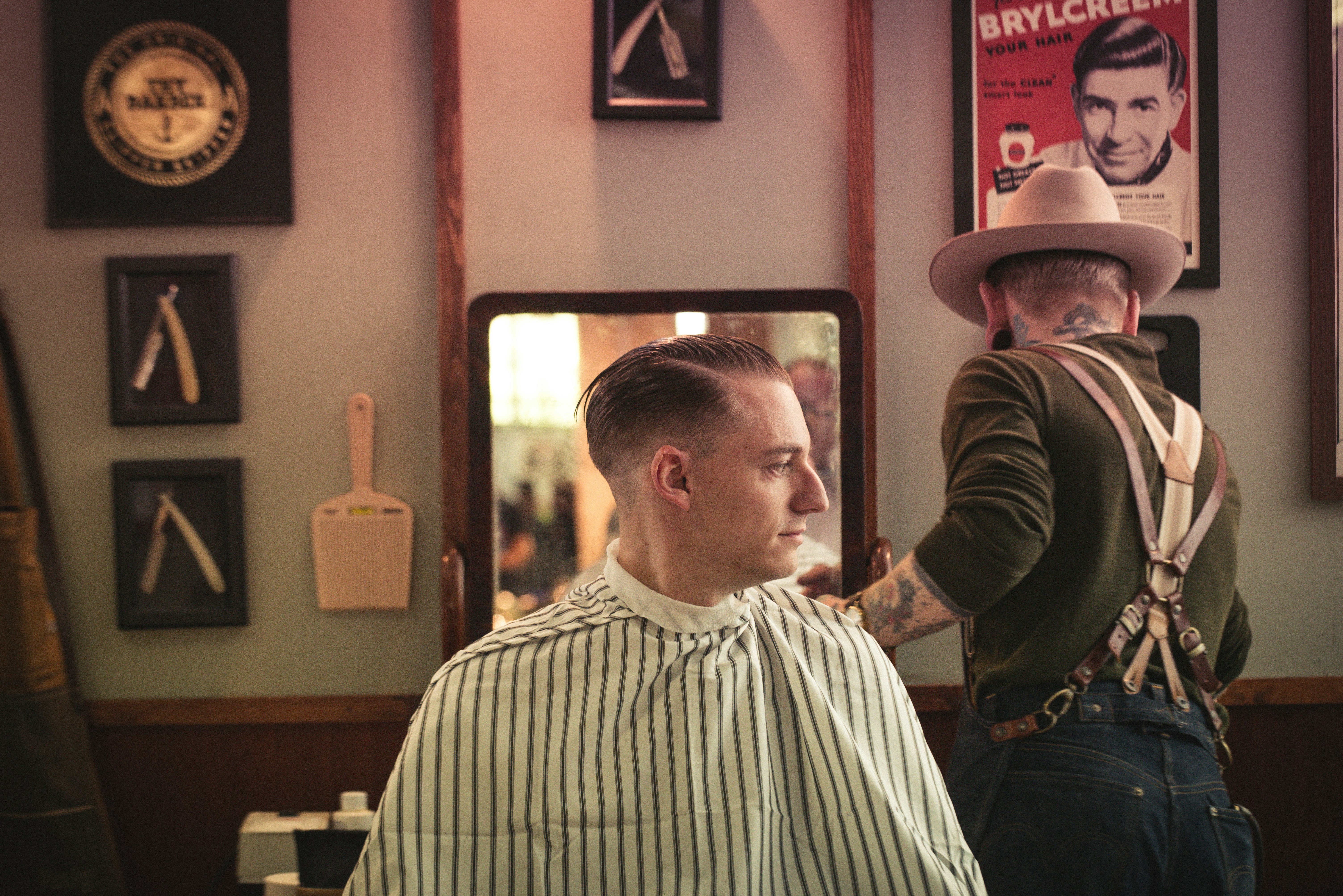 man sitting on chair inside barber shop